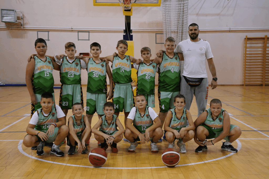 Tim mladih košarkaša u zelenim dresovima na terenu.